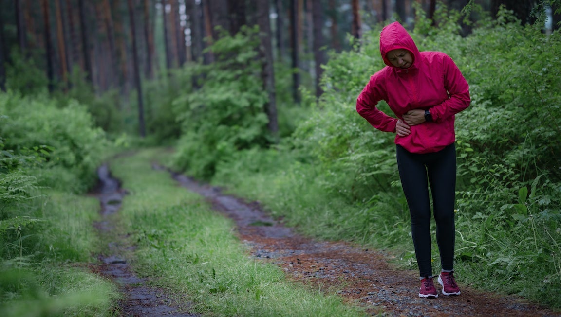 Female athlete. Side stitch - woman runner side cramps after running. Jogging woman with stomach side pain after jogging work out.