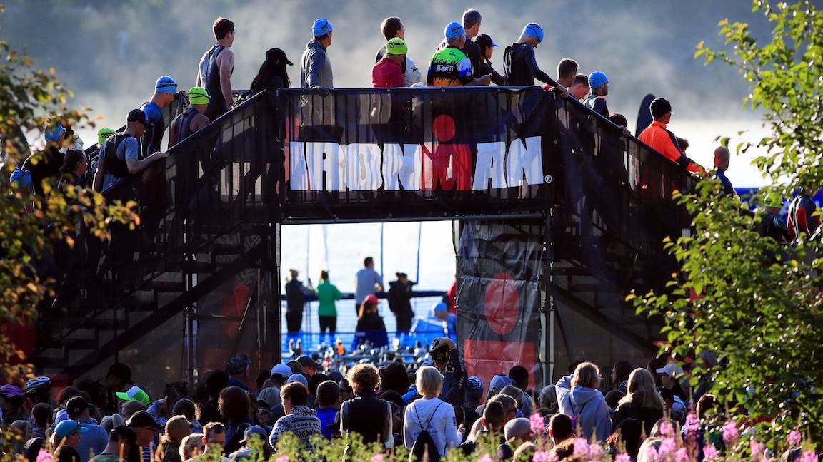 Ironman banner hanging on an elevated walkway at an event with spectators all around.