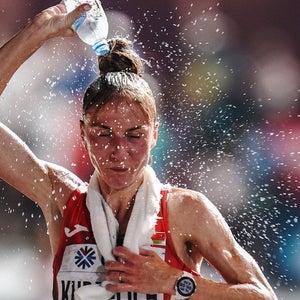 Woman pours water over her head during a race.