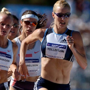 Three women running in a track race.