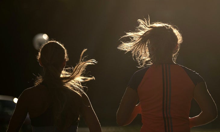 Two women running in the dark.
