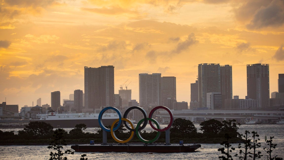 The Olympic Rings in front of the Tokyo skyline.