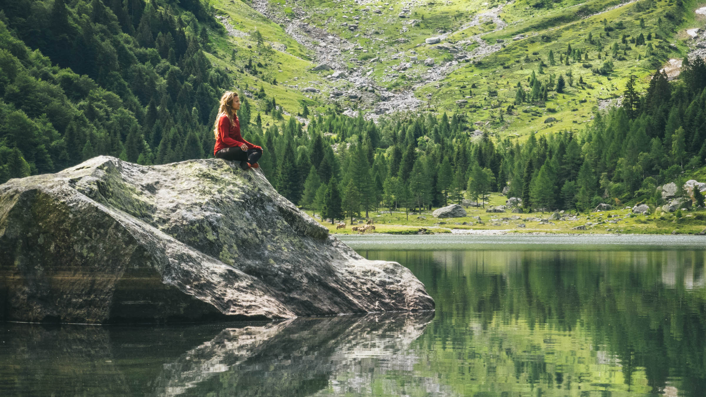 Young woman relaxes by mountain lakeshore