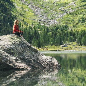 Young woman relaxes by mountain lakeshore