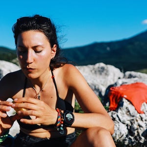 Woman hiking in the great outdoors, in the Dynamic Alps in Southern Europe. She is taking a short break, eating an apple for some extra energy.