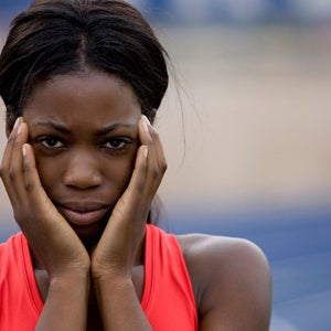 Close-up of female track athlete with hands on cheeks looking super nervous like she might be suffering from pre-race anxiety.