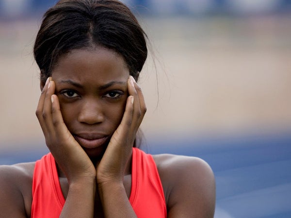 Close-up of female track athlete with hands on cheeks looking super nervous like she might be suffering from pre-race anxiety.