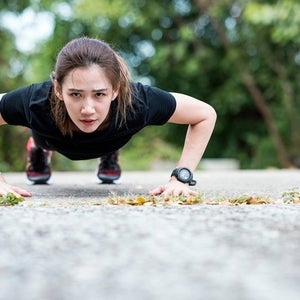Sporty women doing pushing-ups workout on the bridge at urban park outdoors.