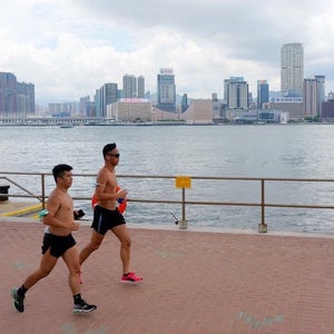 Two men running in the heat in Hong Kong.