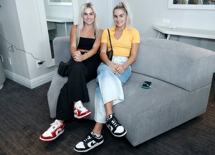 Two Gen Z girls sitting on a couch.