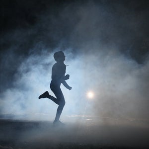 Runner on road in the fog at night