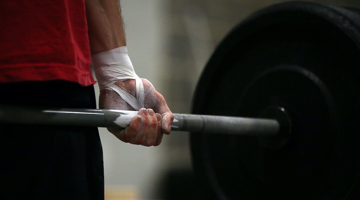 Man holding bar weight.