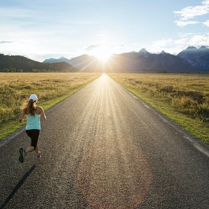 A woman running near the Teton mountains in Jackson Hole, Wyoming.