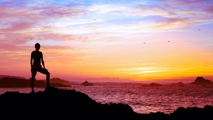 Silhouette of person enjoying beautiful sunset with view of ocean.