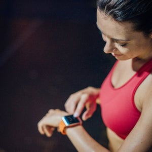 Woman checking pulse with smartwatch after a run.