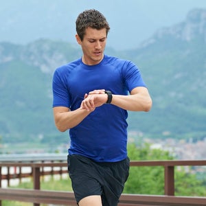 Man running and checking watch.