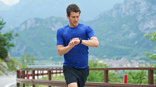 Man running and checking watch.