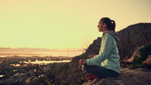 Woman meditating outdoors.