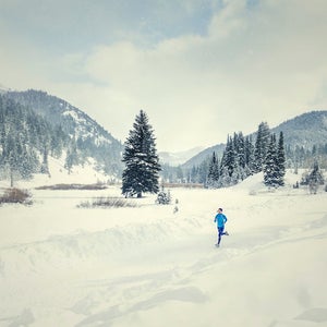 Woman running in snowy landscape.