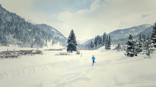 Woman running in snowy landscape.