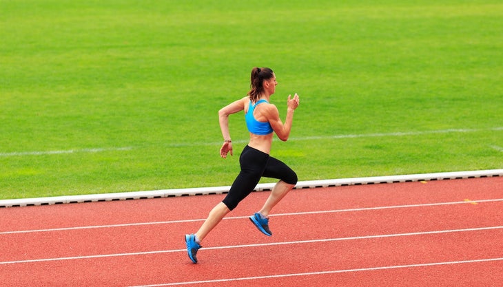 Female sprinter running on sports track.