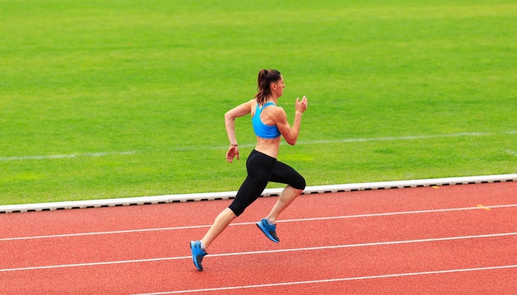 Female sprinter running on sports track.