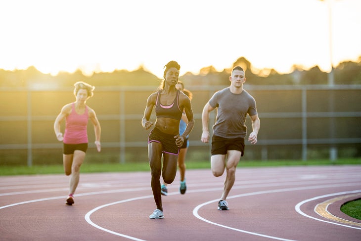 diverse group of runners doing speed work on track