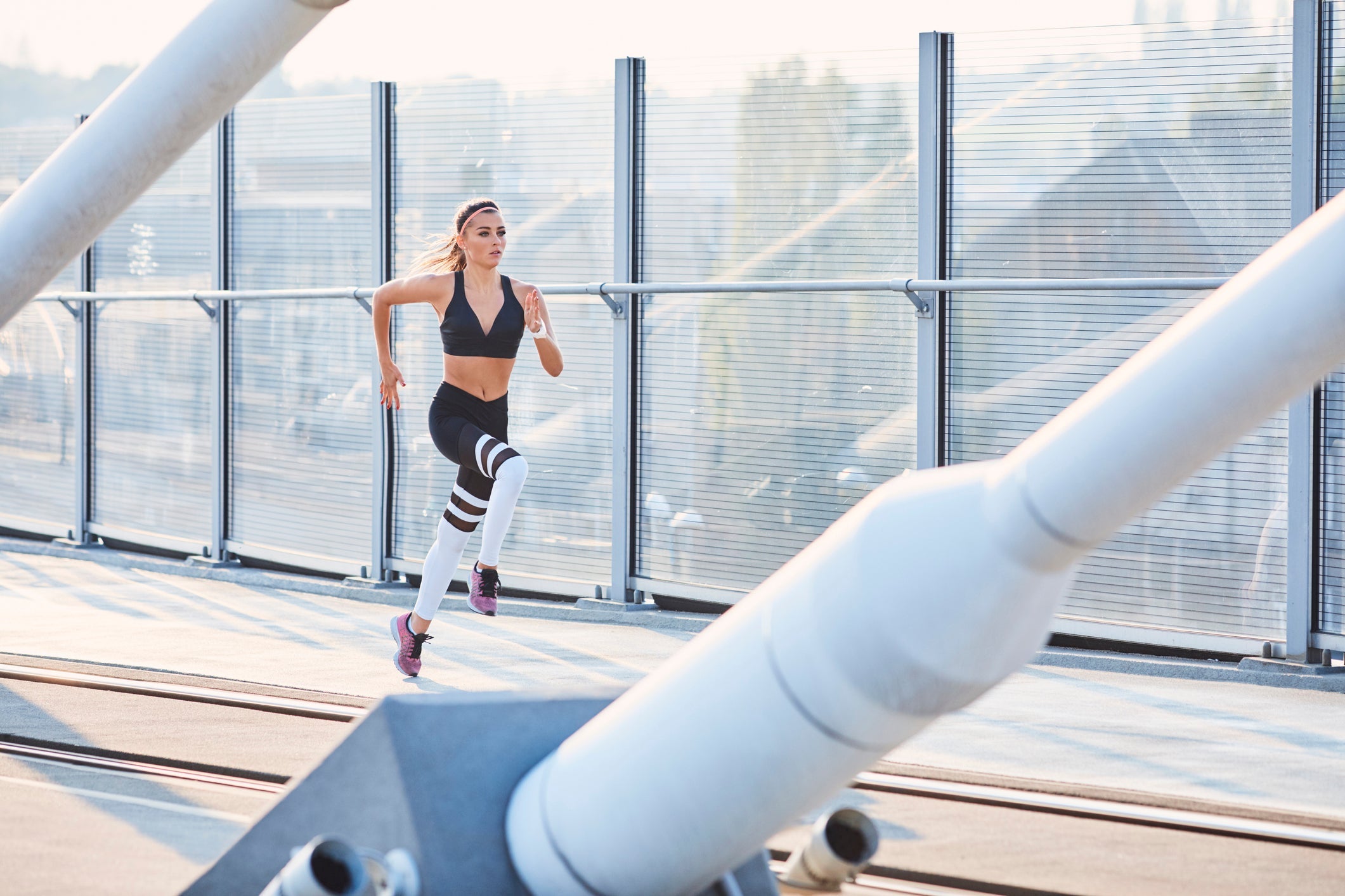 woman sprinting on bridge doing HIT workout
