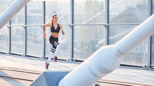 woman sprinting on bridge doing HIT workout