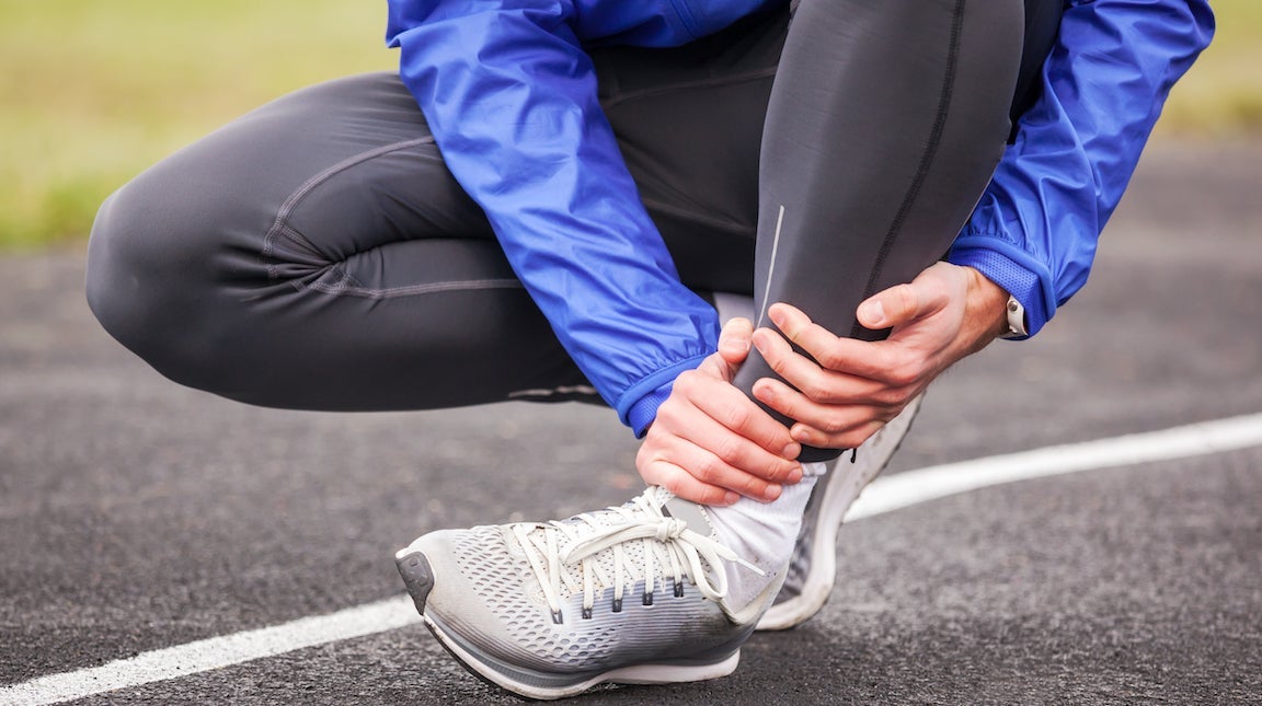 Shot of beautiful female runner standing outdoors holding water