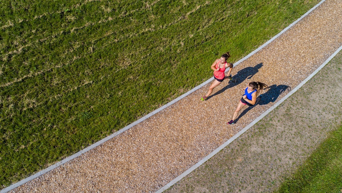 Aerial view of female joggers on woodchip trail.