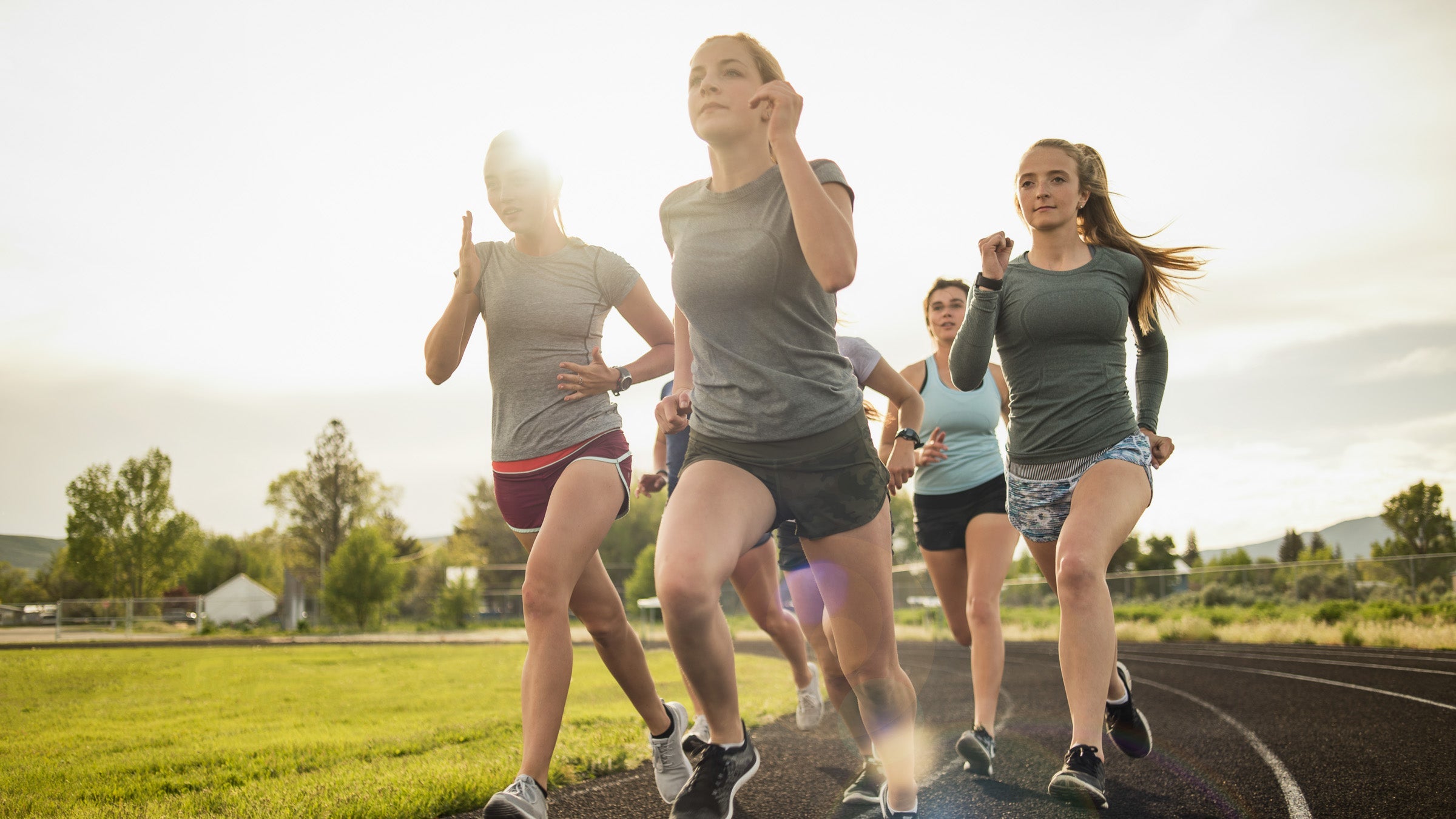 Young women running together on track