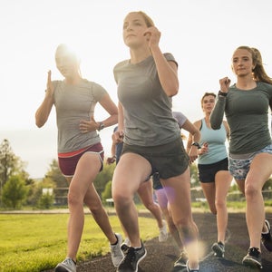 Young women running together on track