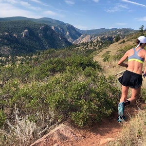Woman running hills on mountain trail