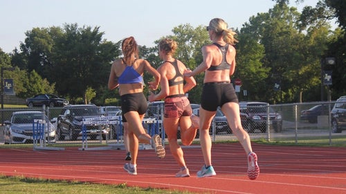 Three women doing a workout on the track.