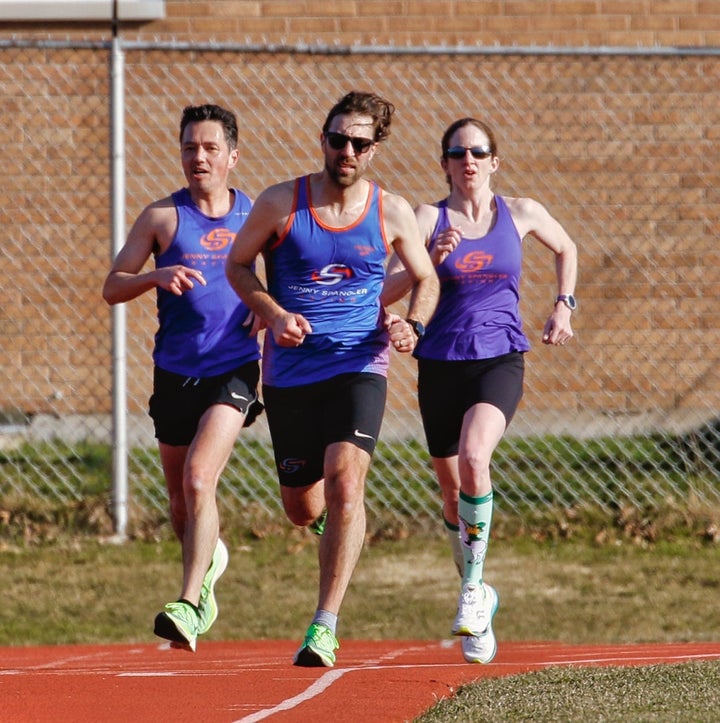 men and woman running intervals on the track
