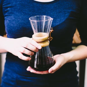 Woman holding carafe of coffee