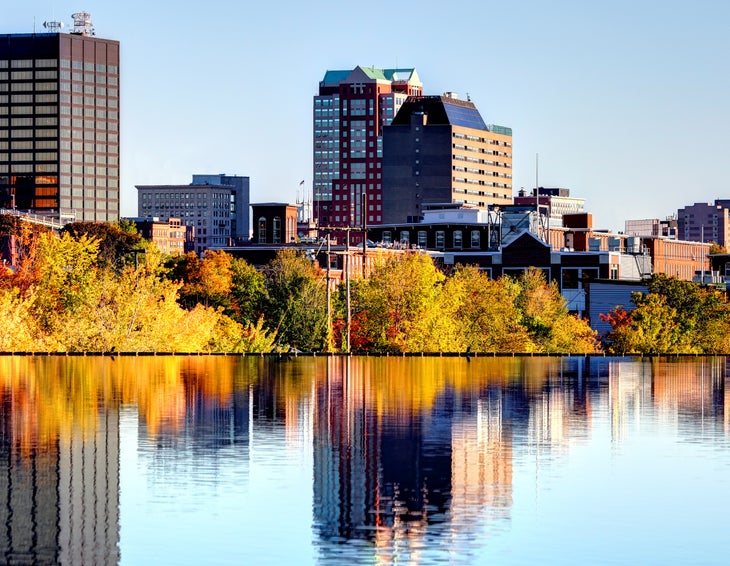 Manchester, NH, in the fall. Picture of city skyline over river in the morning.