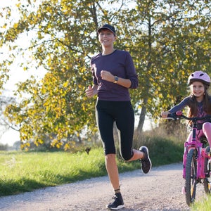 Mother and daughter running outdoors