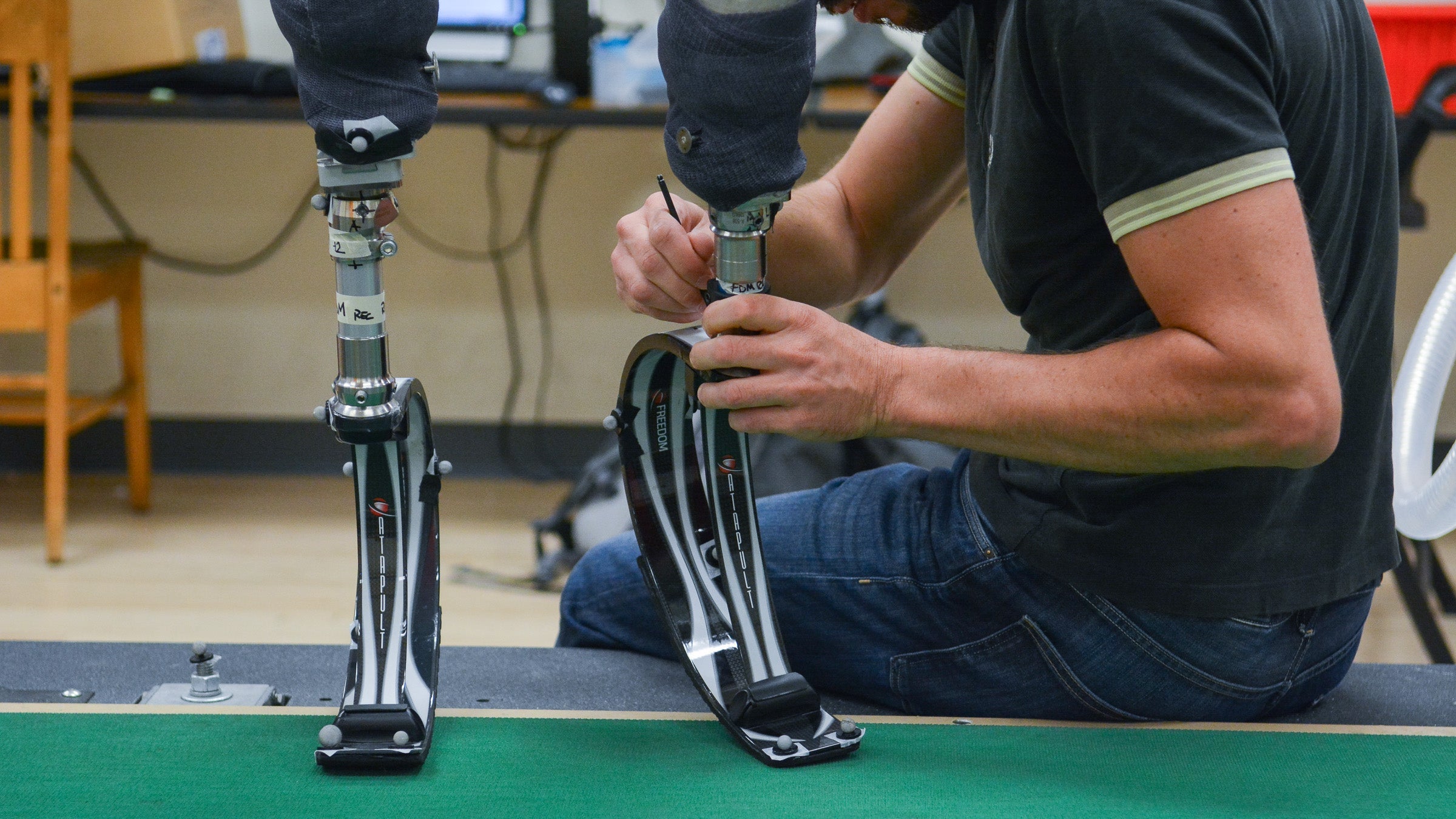 A researcher adjust a running blade prosthetic.