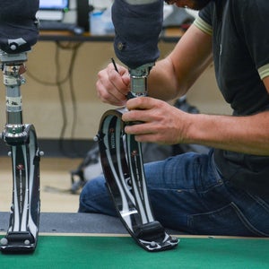 A researcher adjust a running blade prosthetic.