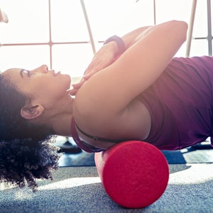 Woman stretching her back with a foam roller