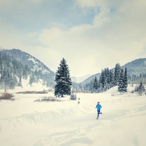 Caucasian woman running in snowy landscape