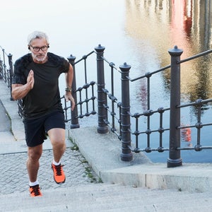 Active senior man running up stairs in the city