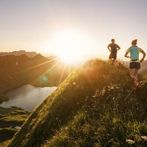 Man and woman running on mountain trail