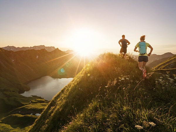 Man and woman running on mountain trail