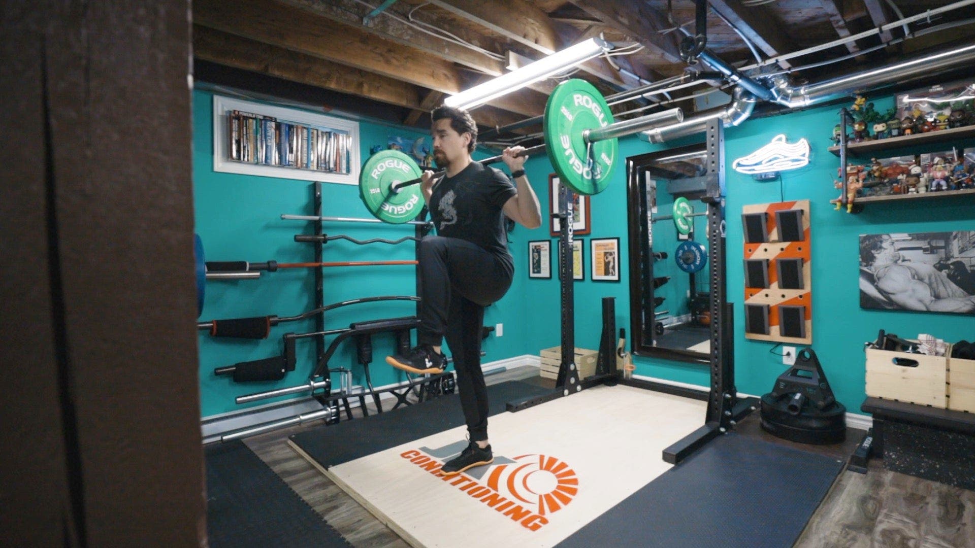 Man with barbell on shoulders lifting knee to chest.
