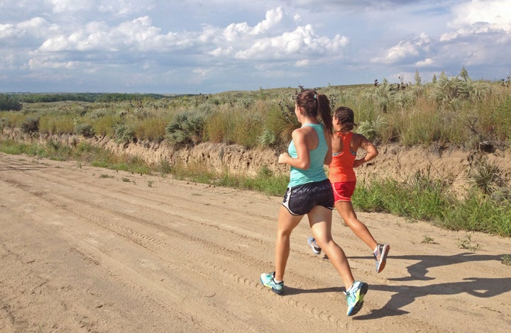 young women runners tempo dirt road