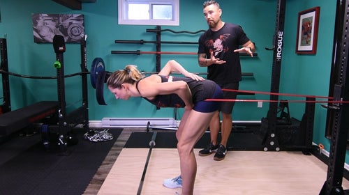 woman doing a banded hamstring workout with a trainer to strengthen hamstrings