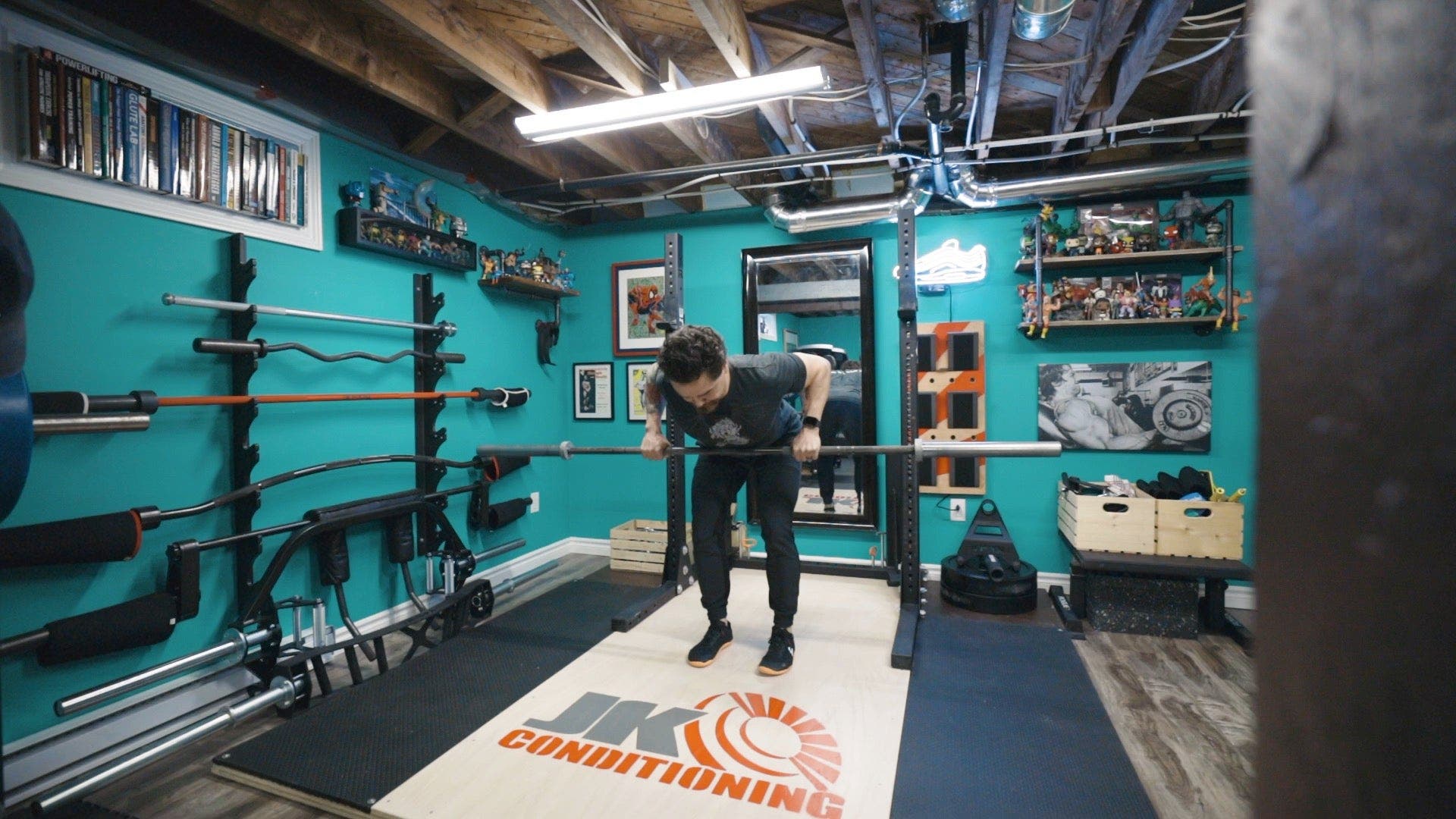 Man lifting barbell into stomach while leaning over, still standing on two feet.